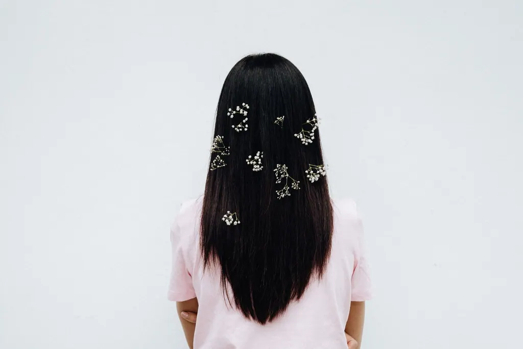 Elegant back view of a woman with long hair adorned with baby's breath on a white background